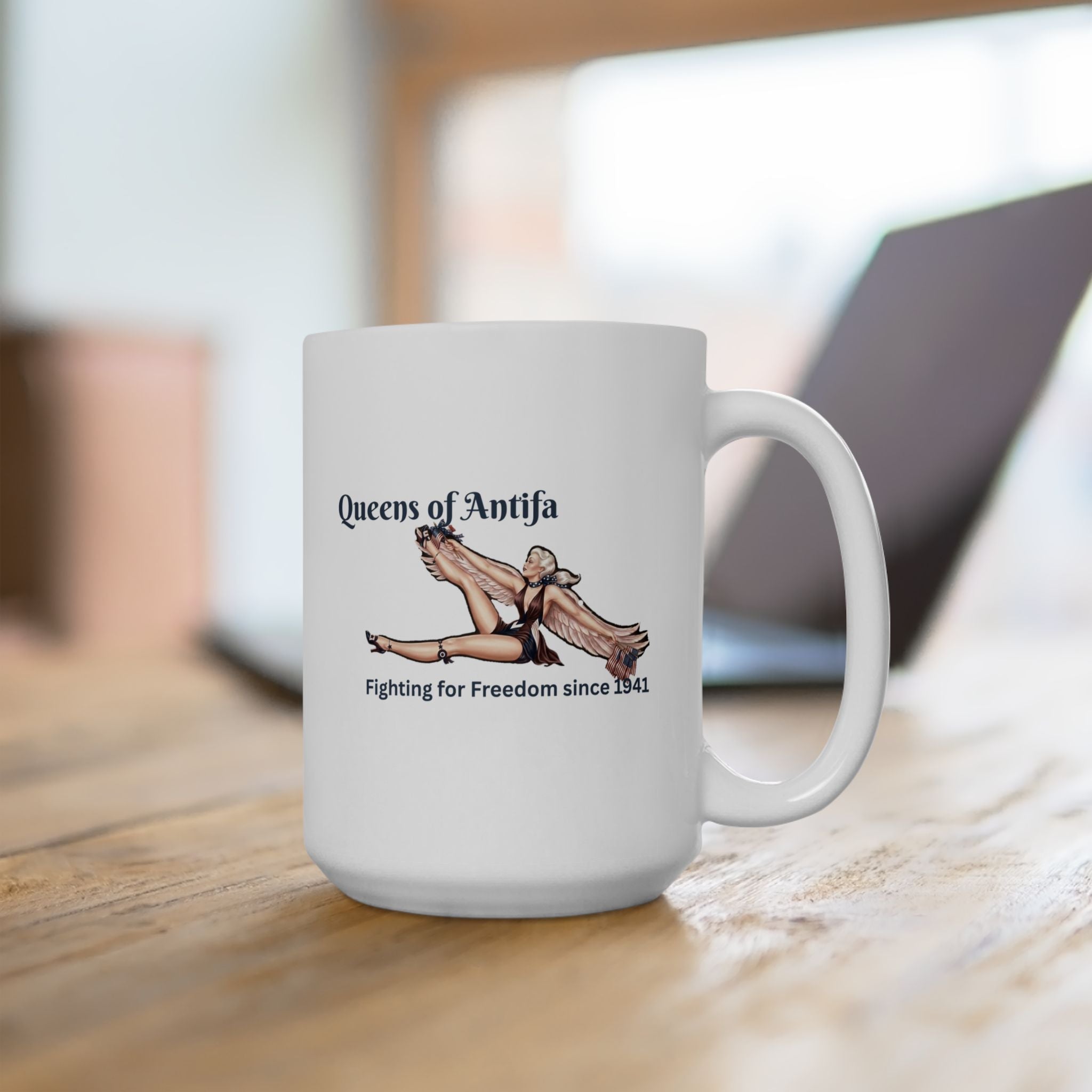 White mug with ‘Queens of Antifa’ and a picture of a vintage, retro-style winged woman and ‘Fighting for Freedom since 1941’.